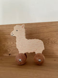 Holz-Alpaka auf Rädern